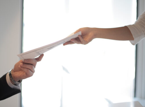 Hands of two business people passing documents from one to the other