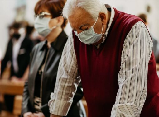 Attendees of funeral services wearing covid masks inside funeral home