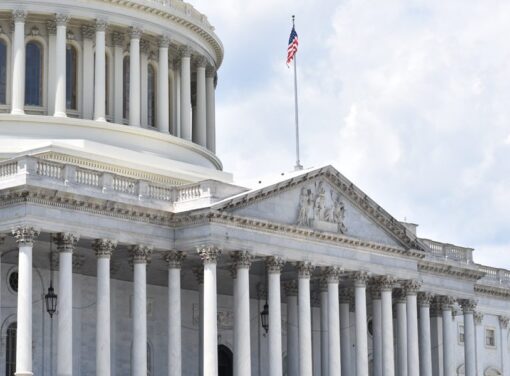 Close up shot of U.S. Capitol building with flag raised
