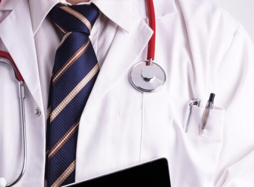 Close up of male doctor with white coat, stethescope, tie and pen