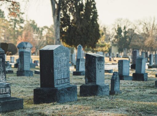 Old tombstones in a cemetary with morning sun rising in the background
