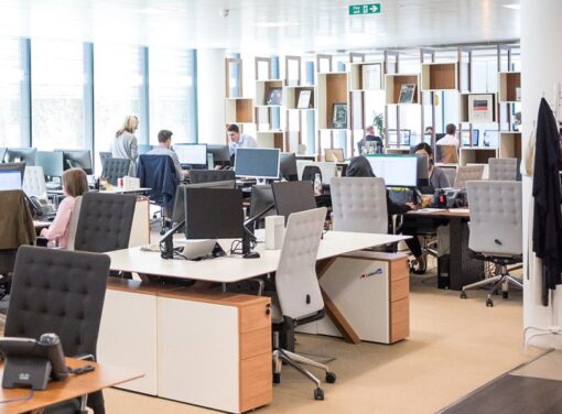 Open business office setting with colleagues working at their desks