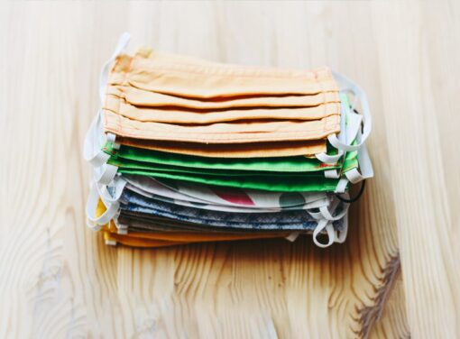 Stack of COVID-19 face masks on wooden table