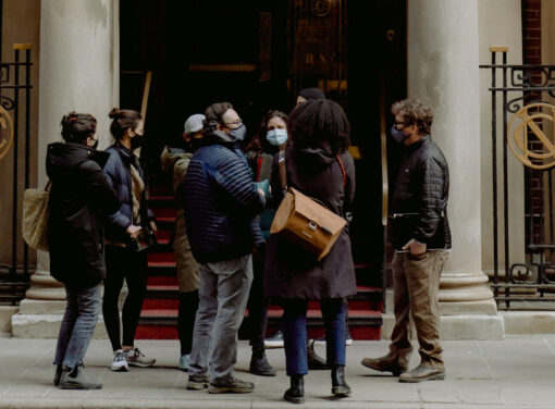 Group of people with masks on waiting to enter a building together