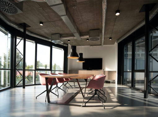 Modern office meeting room with table in center surrounded by glass walls