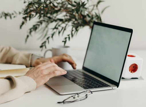Desk with laptop and someone typing