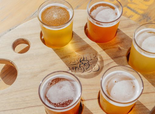 Five cups of beer on a wooden tray