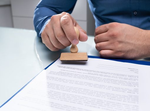Close-up Of Businessman Hand Using Stamper On Document
