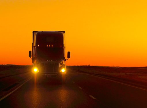 truck driving on highway at dusk