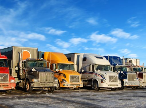 big rig trucks parked in a line