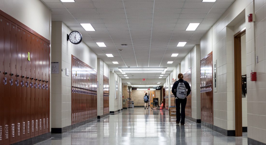 High school student walks down hallway