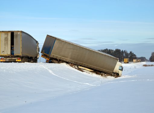 Trucking accident on snowy road.