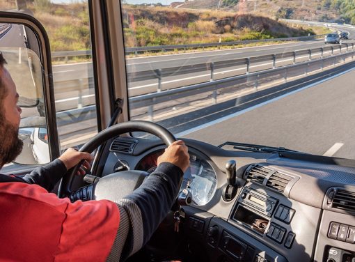 truck driver in driver's seat on highway