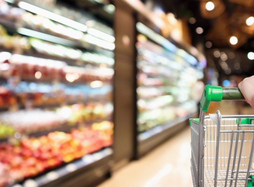 woman pushing cart in grocery store aisles