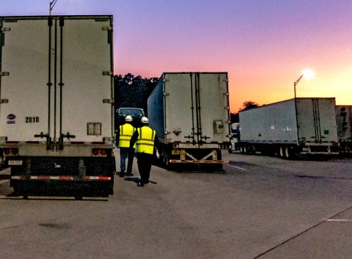 Two truck drivers walking to their truck in parking lot during sunset