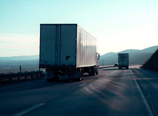 Semi truck driving down highway with valley in background