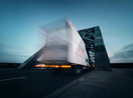 Semi truck driving over bridge at dusk
